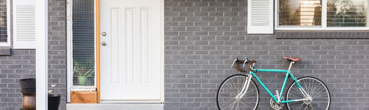 Medium angle of front porch of gray brick house.