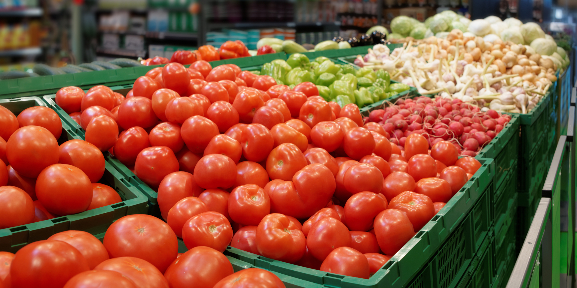 Medium angle of vegetables in plastic crates at a supermarket.