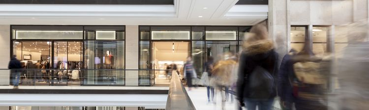 Medium angle of people walking through multi-story shopping mall.