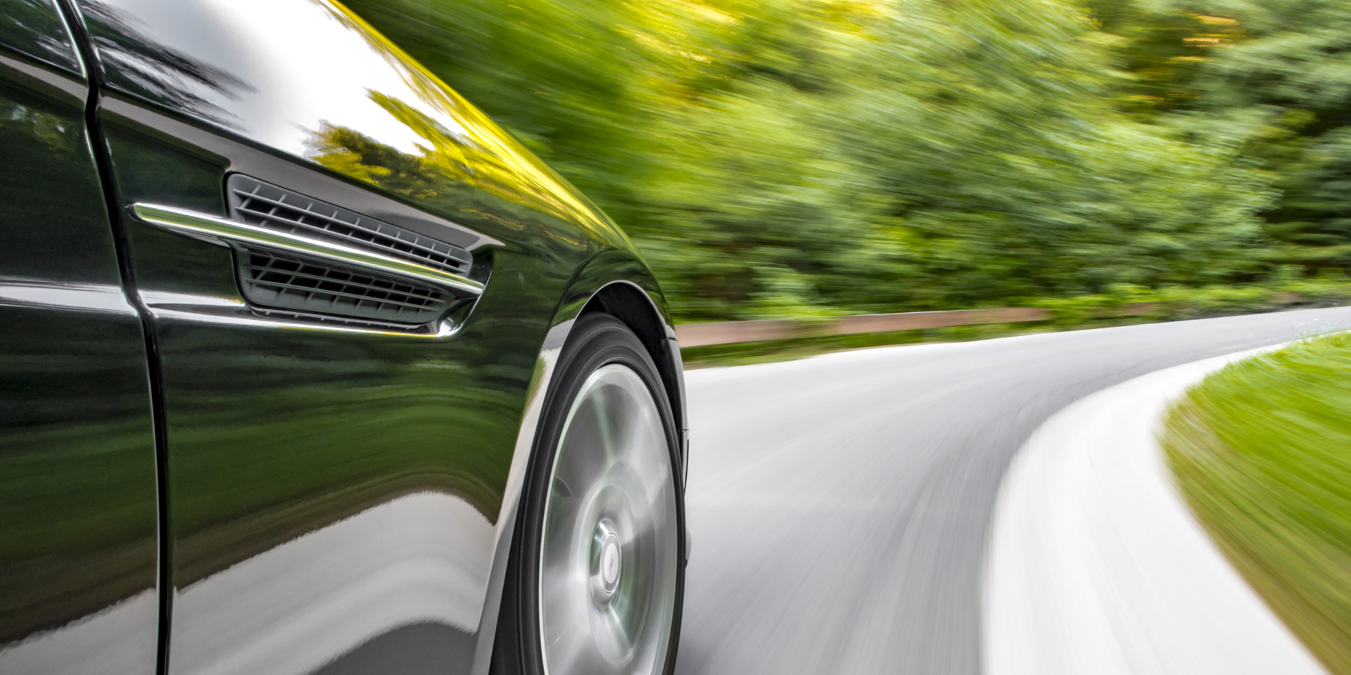 Motion blur shot of a sports coupe driving fast in a curve