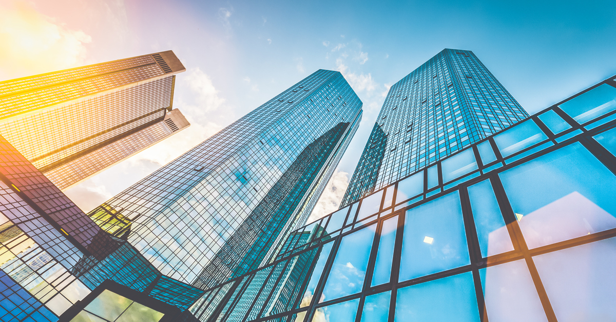 Bottom view of modern skyscrapers in business district in beautiful evening light at sunset with monochrome retro vintage Instagram style filter and lens flare effect