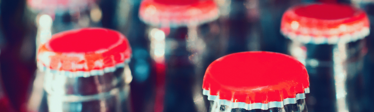 Close-up of red bottle caps on glass beverage bottle.