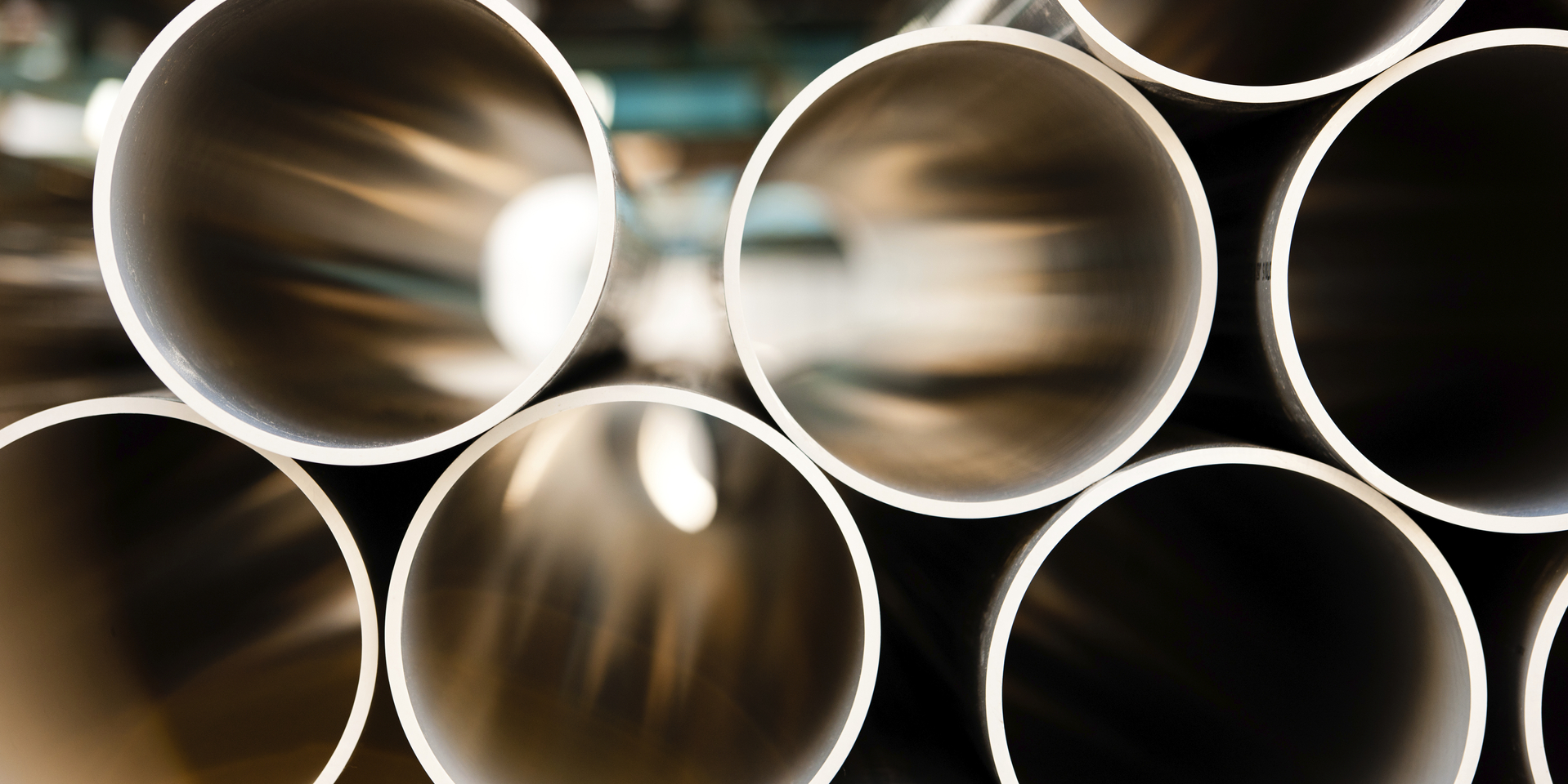 Close-up looking through stacked metal pipes.