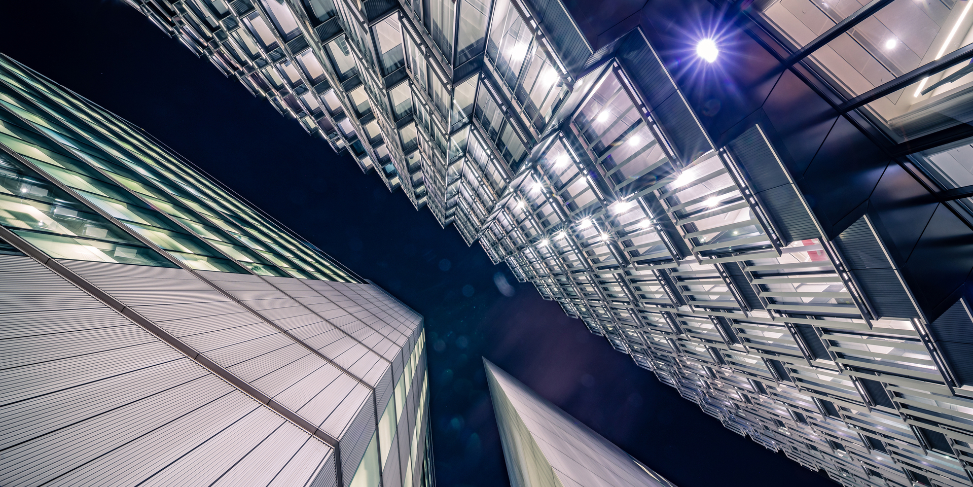 Highly detailed abstract wide angle view up towards the sky in the financial district of London City and its ultra modern contemporary buildings with unique contemporary architecture during night time. Shot on Canon EOS R full frame with 14mm wide angle prime lens. Image is ideal for background with copy space and no people.