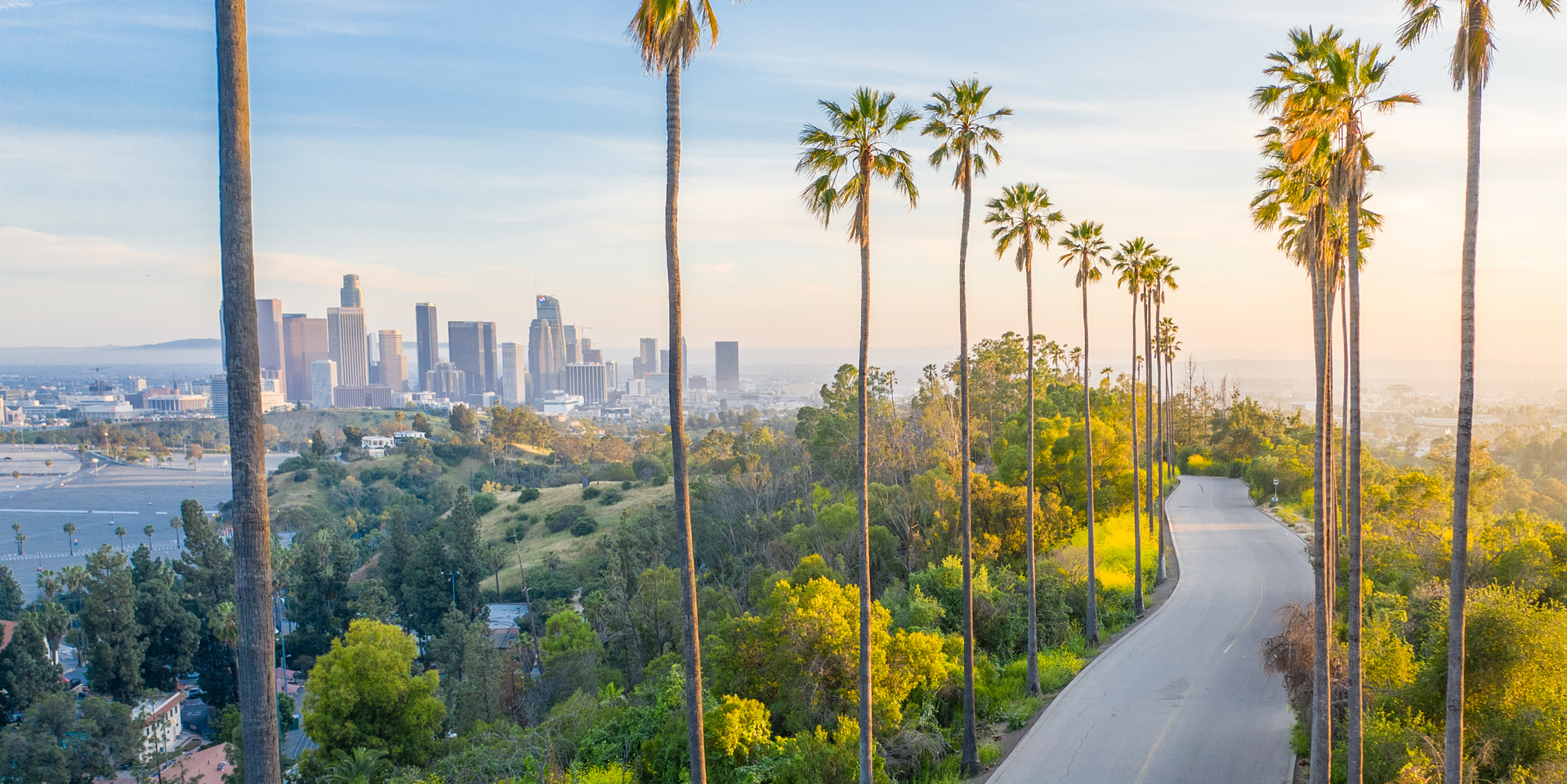 Drone shot of a woman walking down a street toward Downtown Los Angeles.