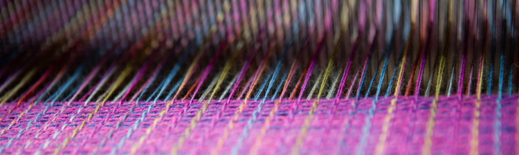 Close up detail shot of weaving being done on a traditional Ecuadorian loom.