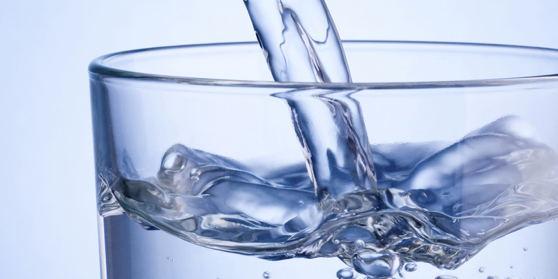 Close-up of water being poured into drinking glass.